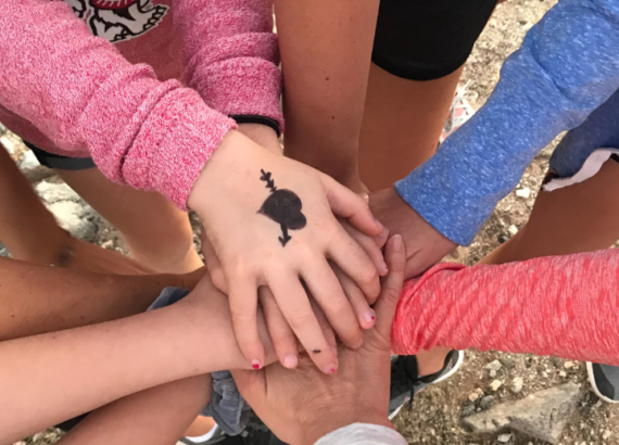 girls group in a circle holding hands with Whitney Shevlin Therapist